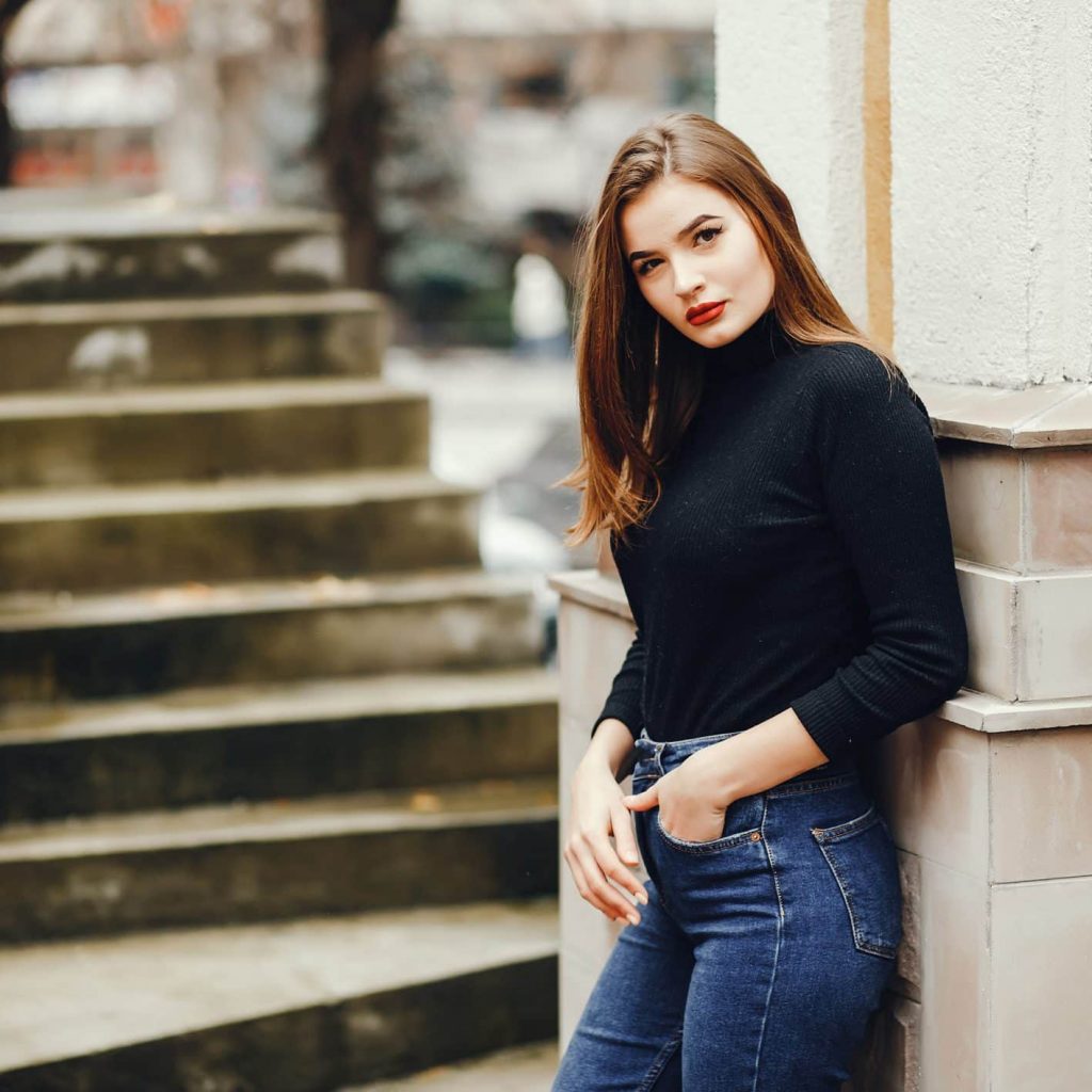 Beautiful girl in a town. Woman at the stairs. The girl is outdoors